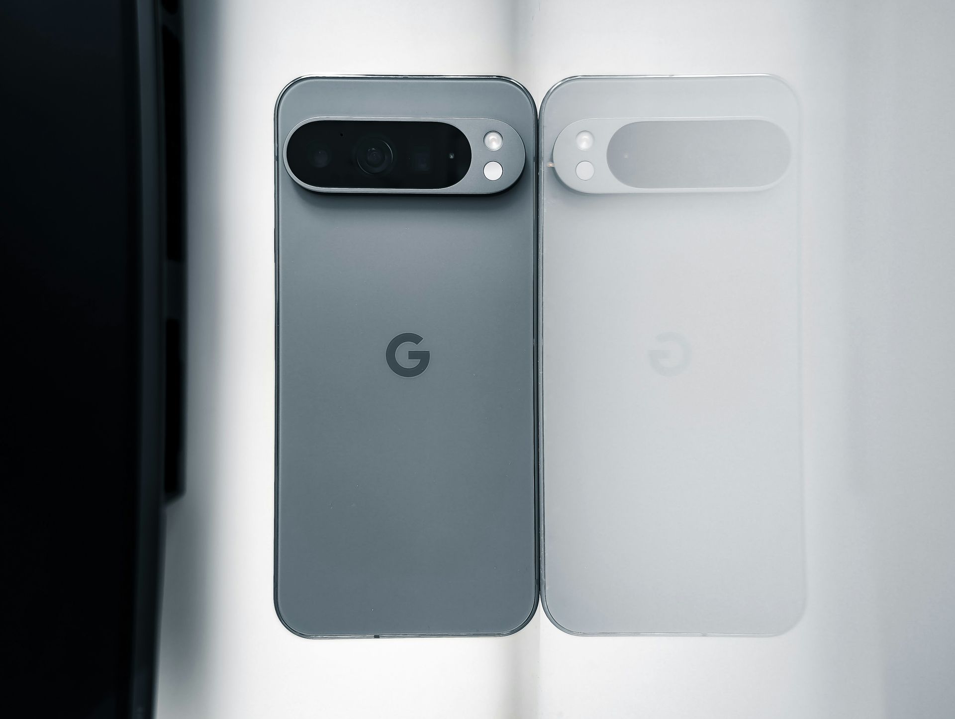 Two Google Pixel phones, one dark gray and one white, shown side by side with rear cameras visible