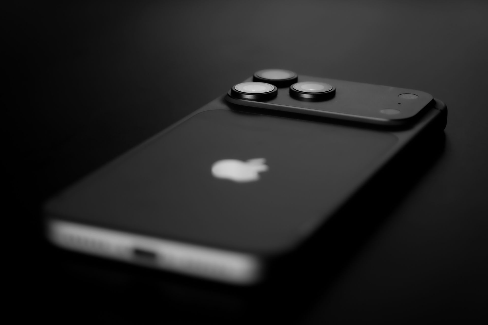 Black iPhone with dual cameras on a dark background