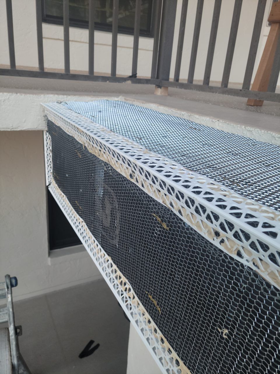 A mattress is sitting on a balcony next to a railing.