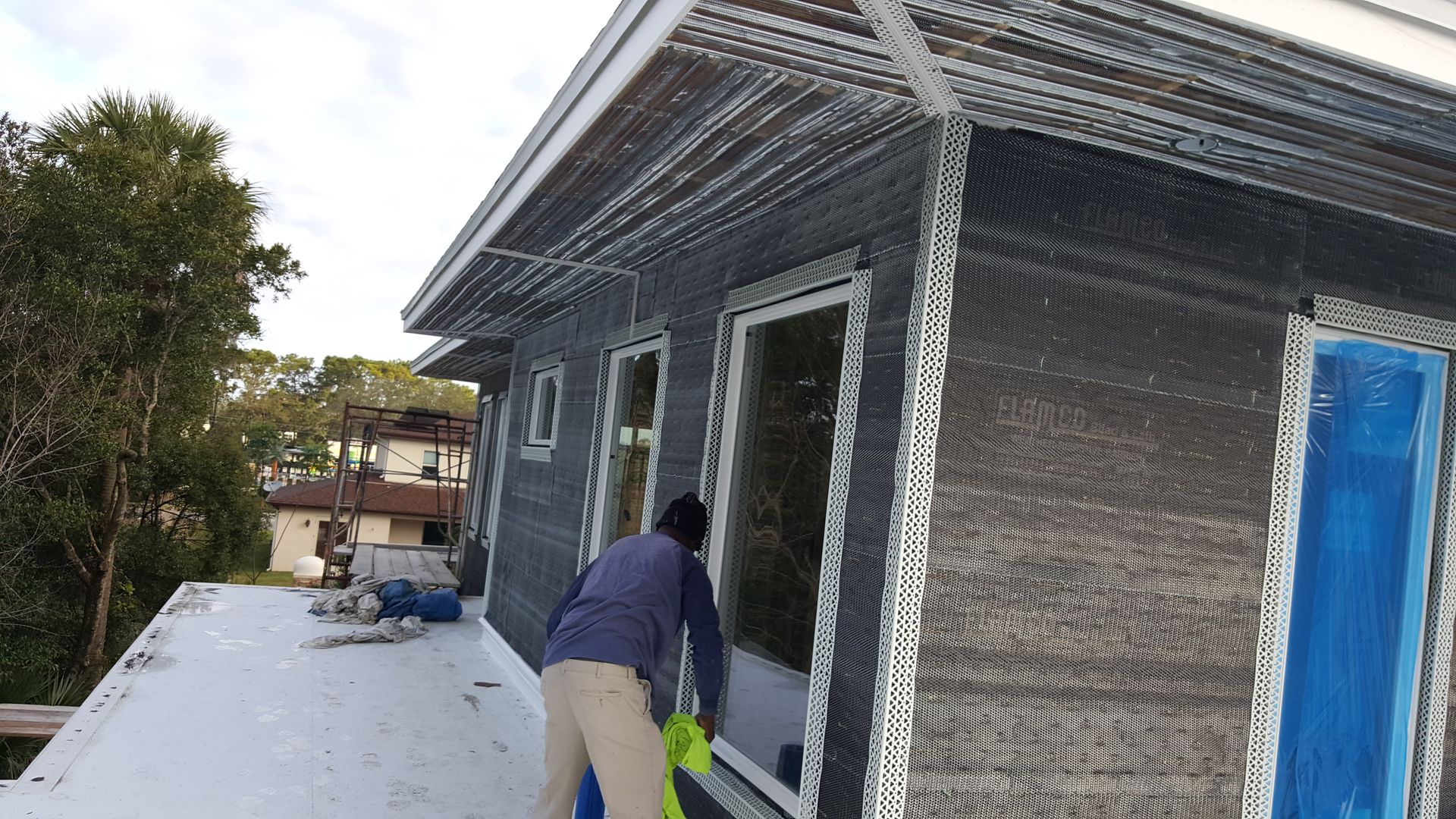 A man is standing on the roof of a house.