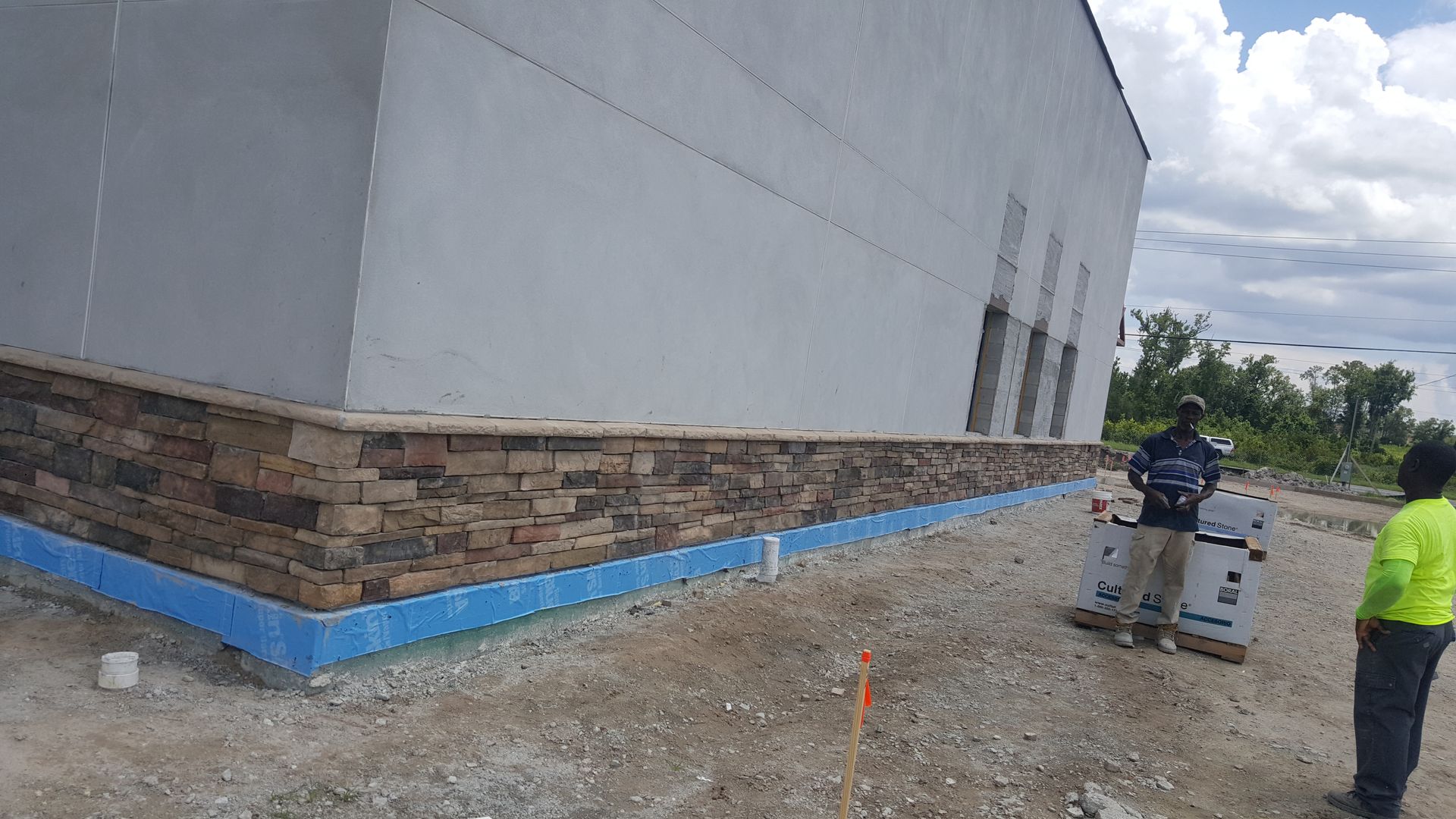 A man is standing in front of a building under construction.