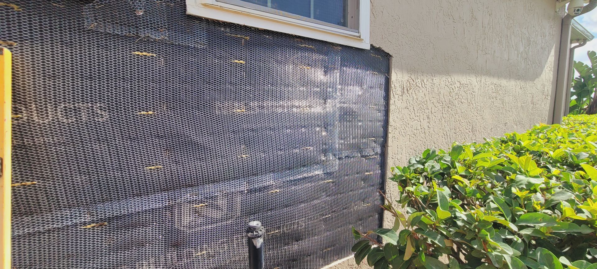 A house with a black tarp on the side of it.