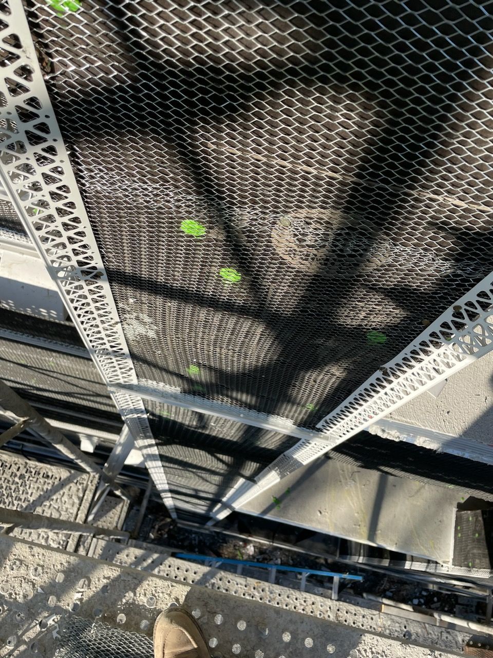 A person is standing on a scaffolding on top of a building.