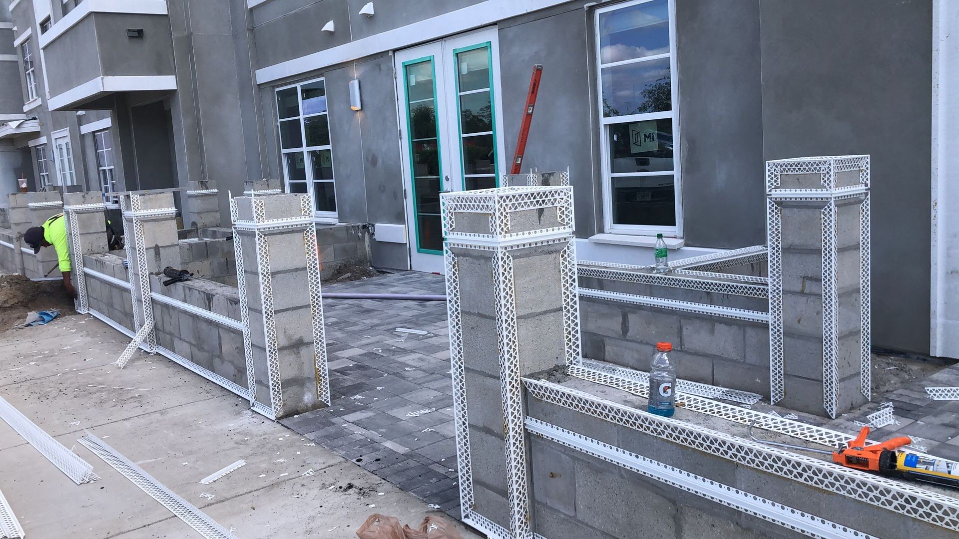 A brick wall is being built in front of a building.