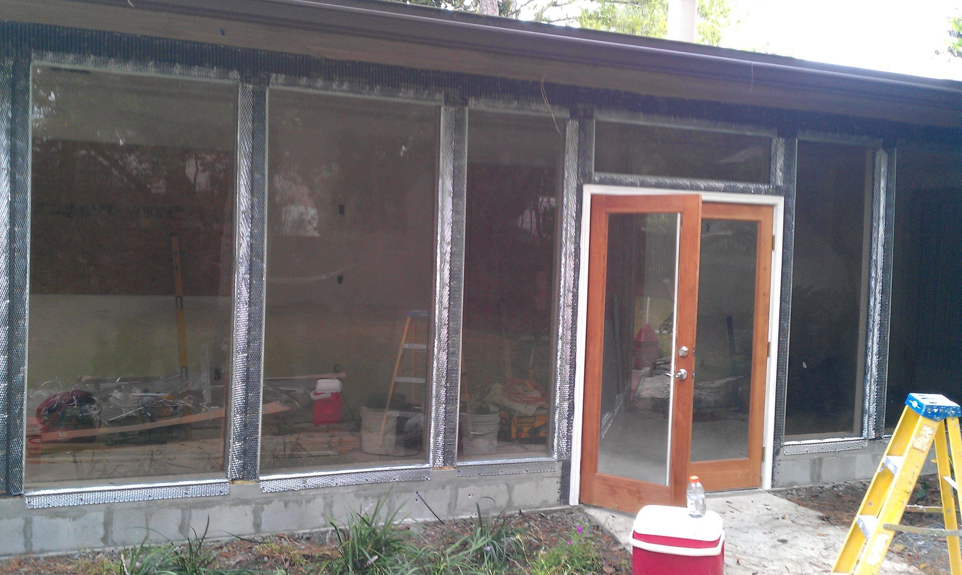 A house with a lot of windows and a ladder in front of it