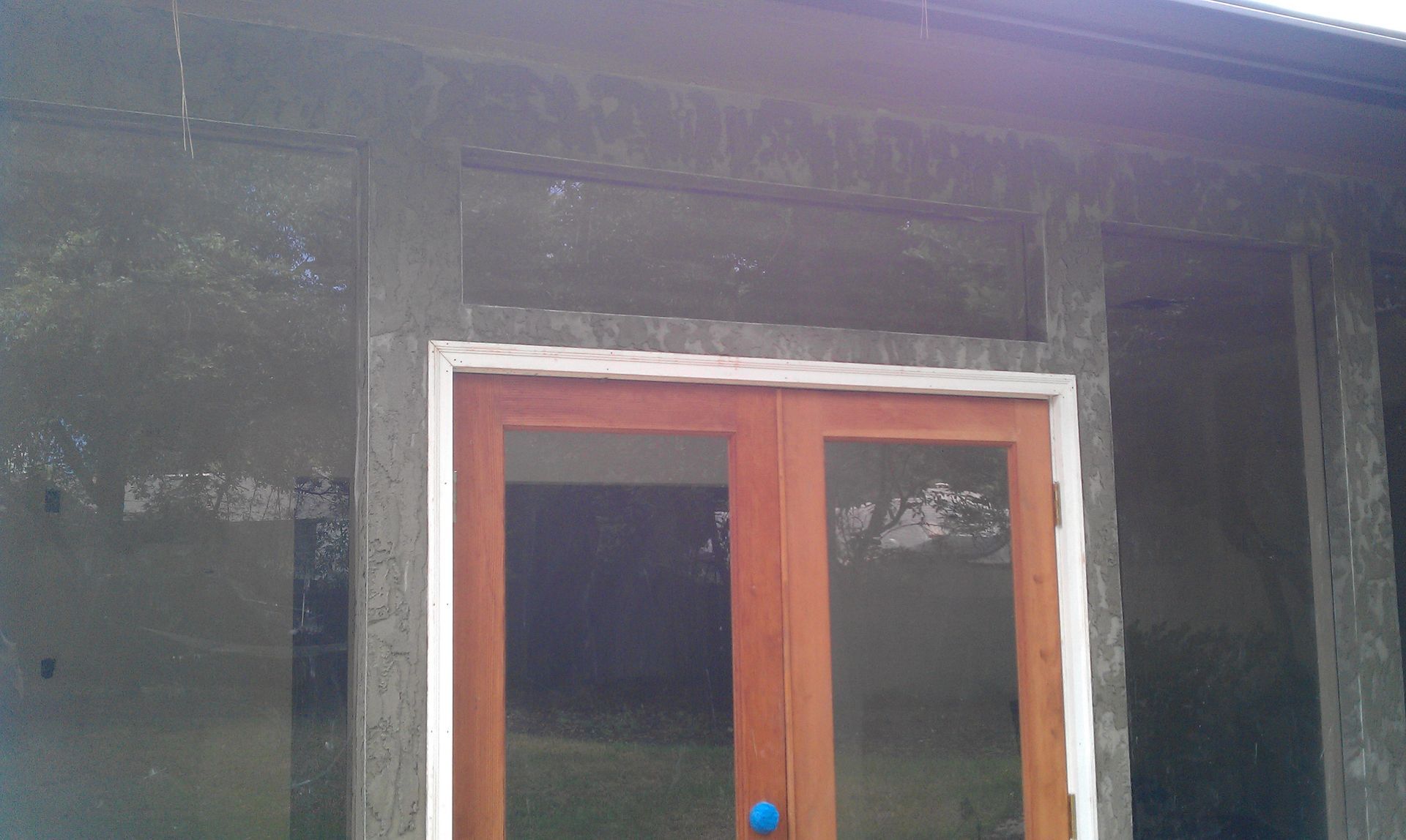 A wooden door is sitting on the side of a building.