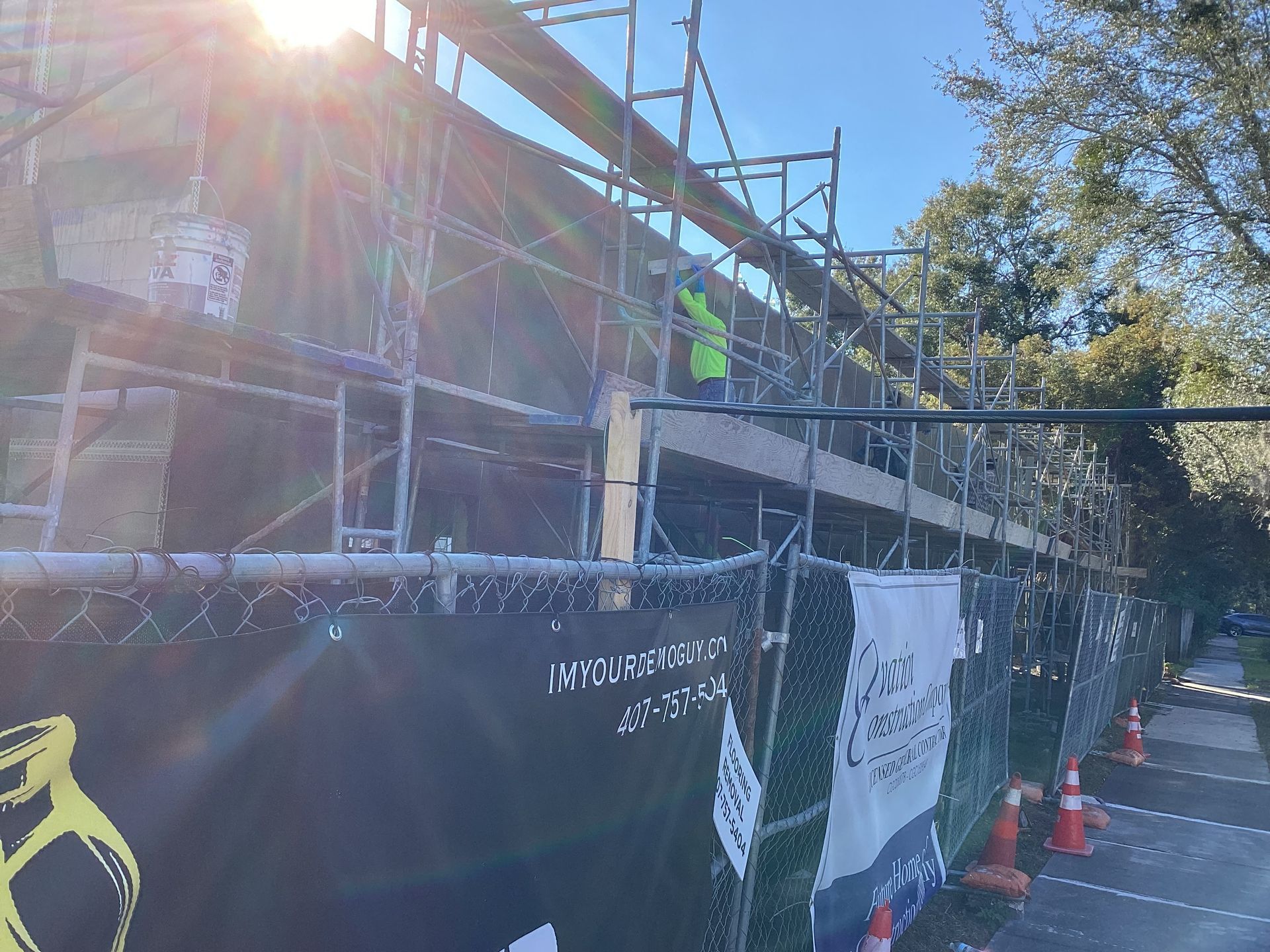 A construction site with scaffolding and a fence surrounding it.