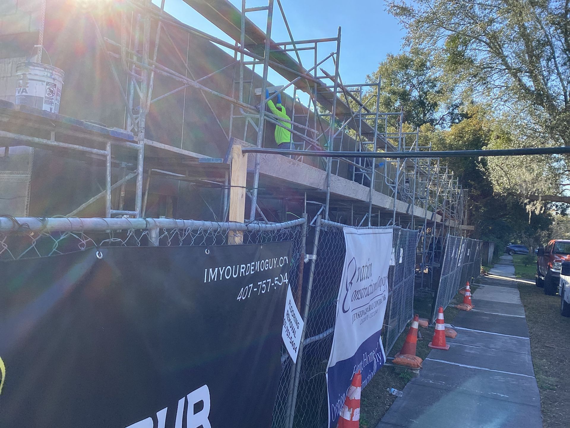 A construction site with scaffolding and a fence surrounding it.