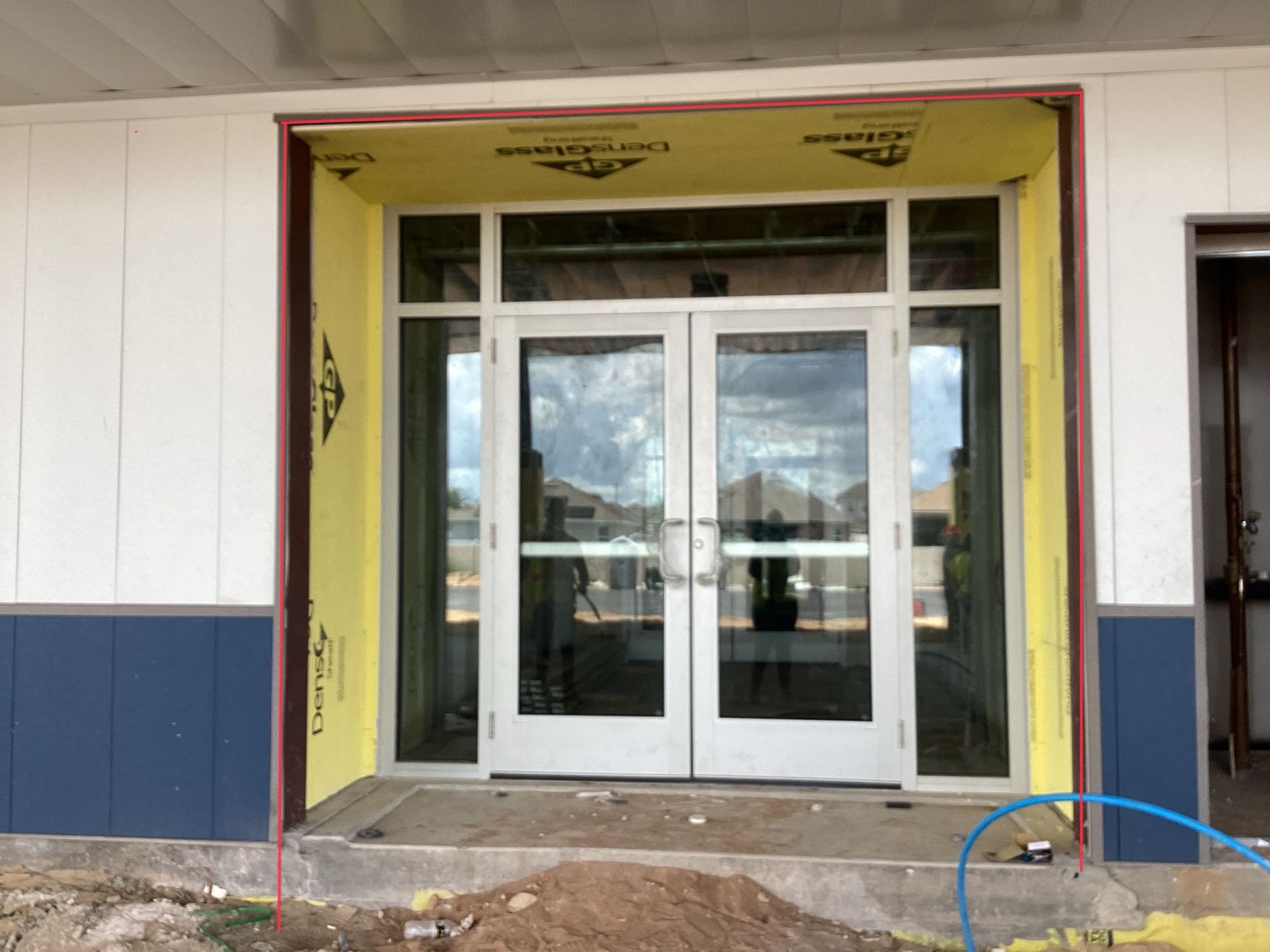 A building under construction with a lot of windows and doors.