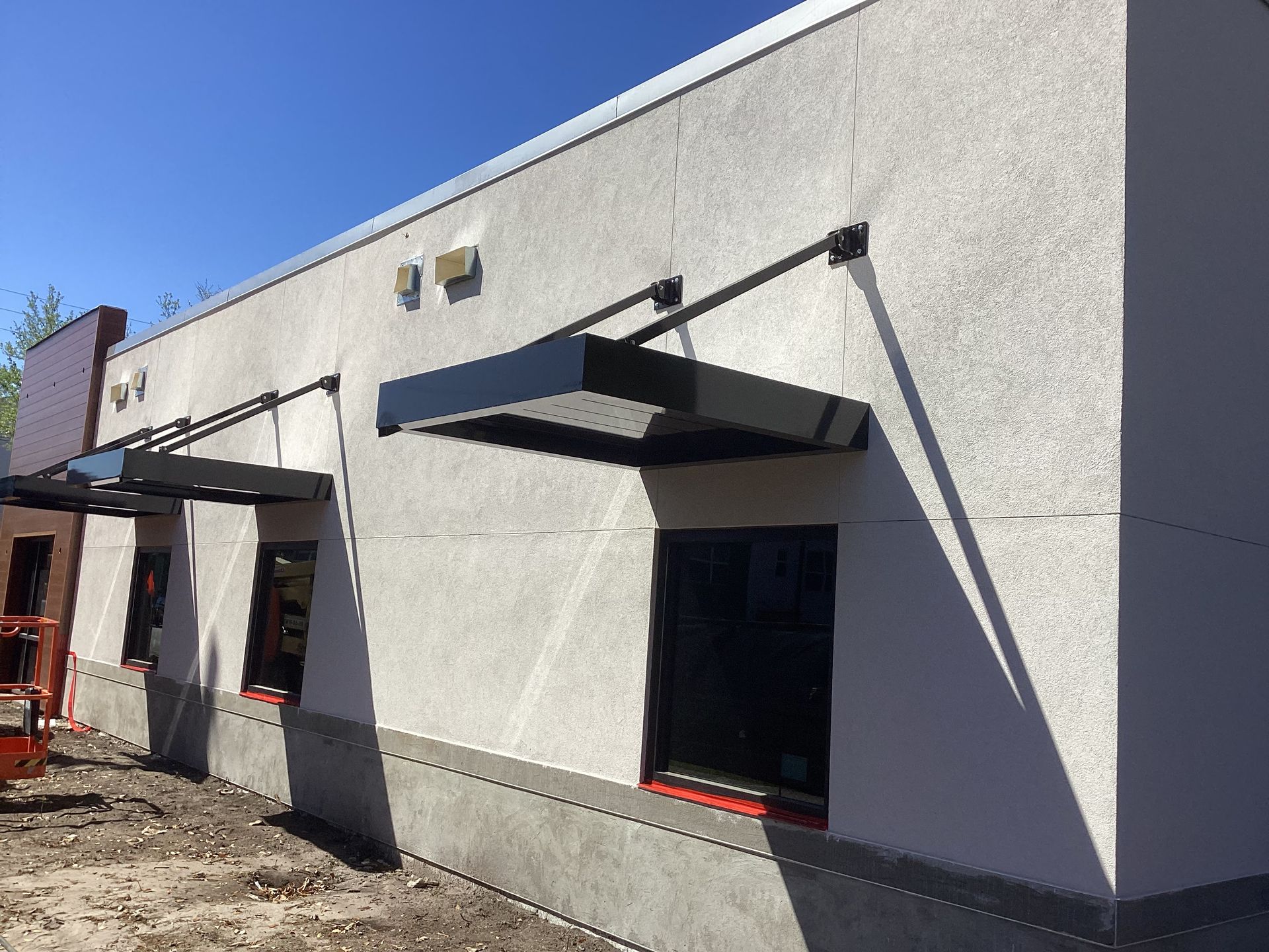 A white building with a canopy on the side of it