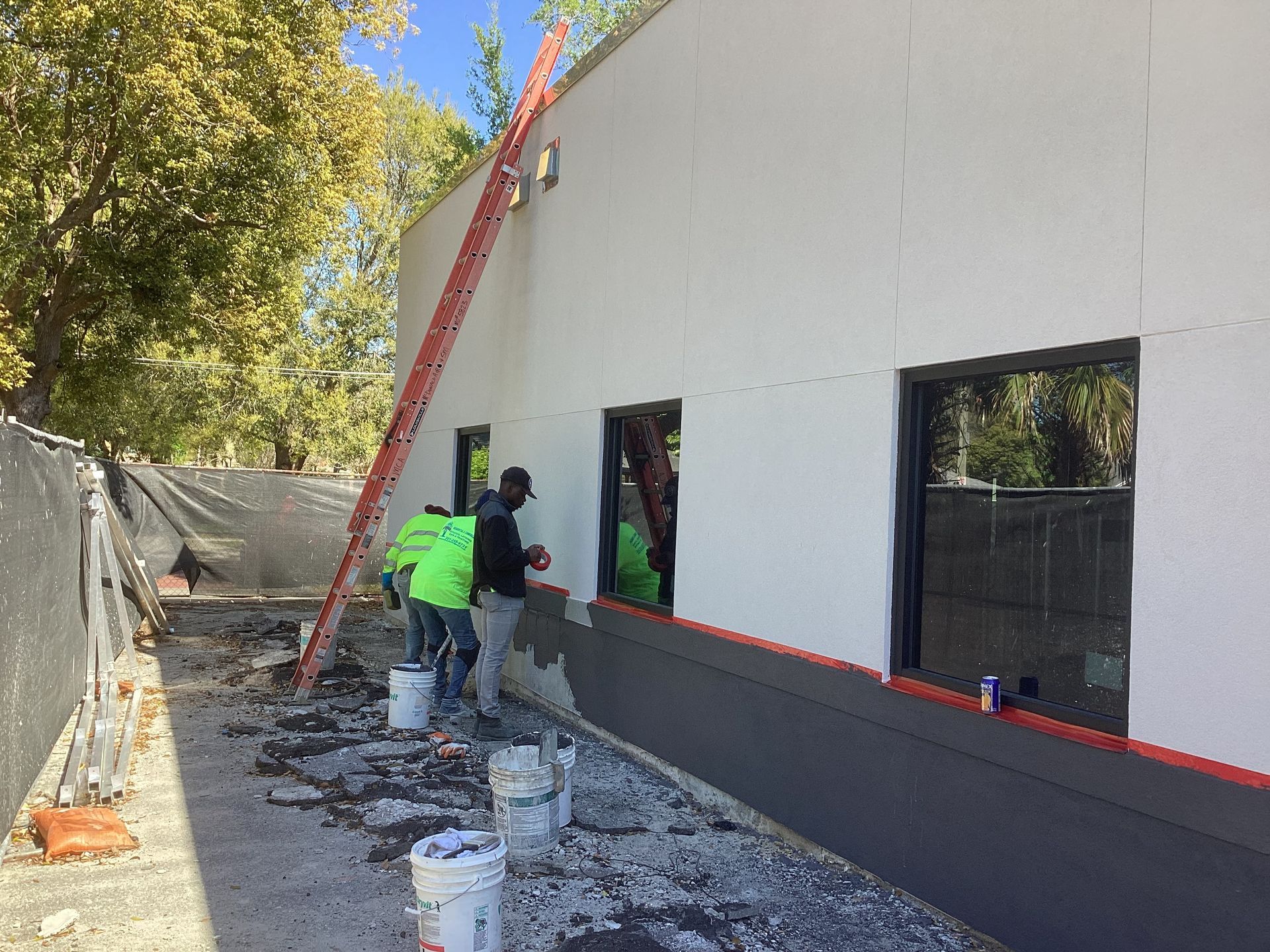 A group of construction workers are working on the side of a building.