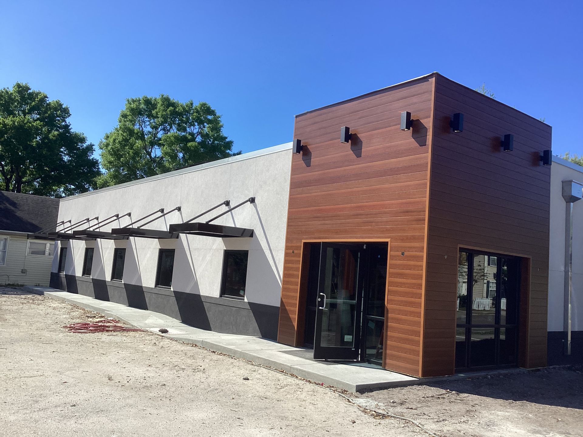 A white building with a wooden facade and a lot of windows