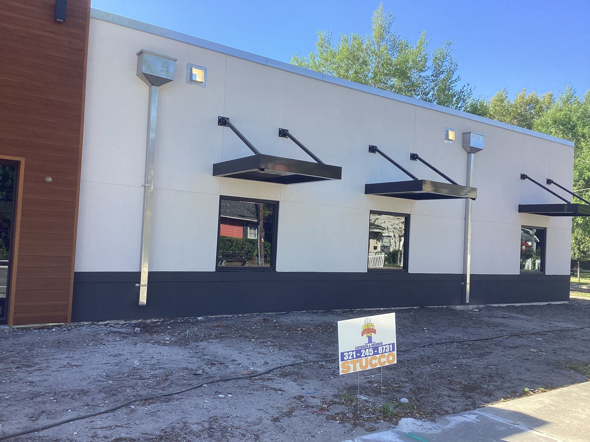 A building with awnings on the side of it and a sign in front of it.
