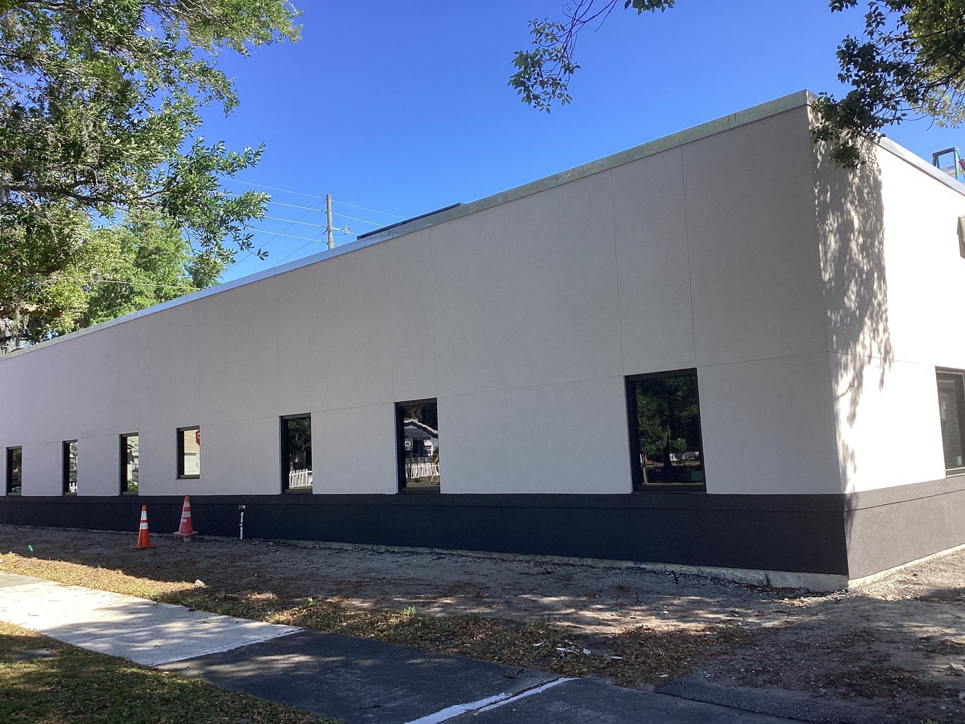 A large white building with black trim and a lot of windows.
