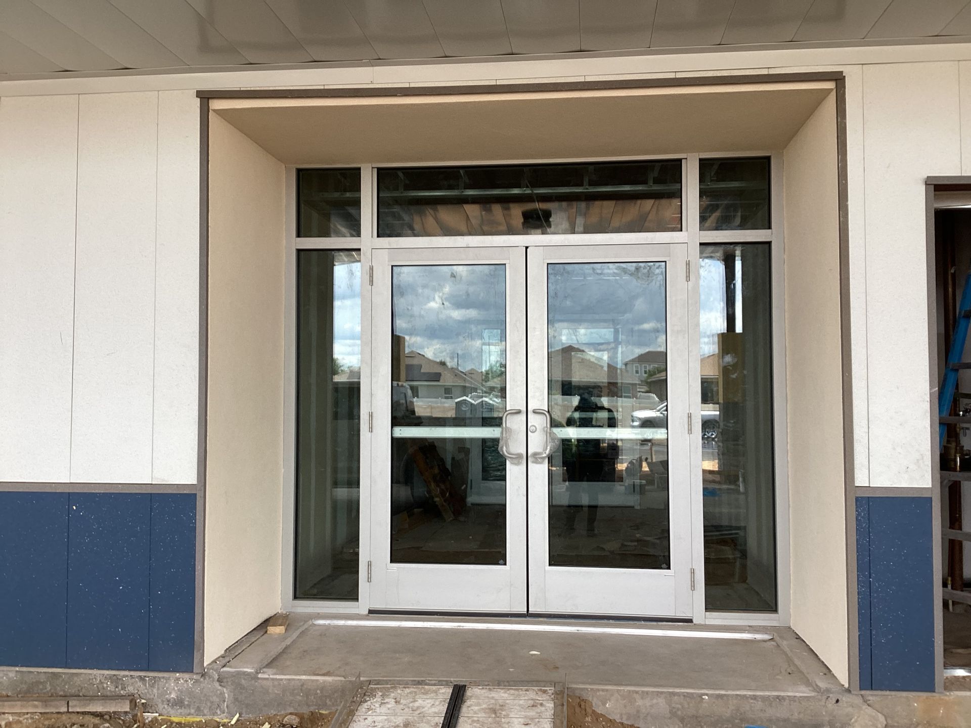 A building under construction with a large glass door