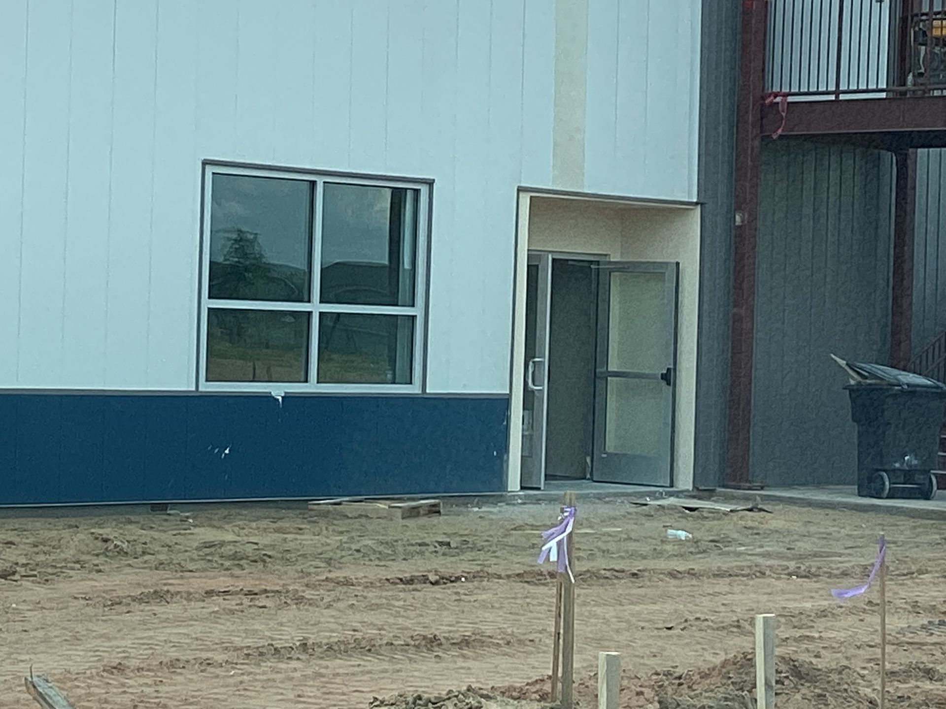 A white building with a blue trim is under construction