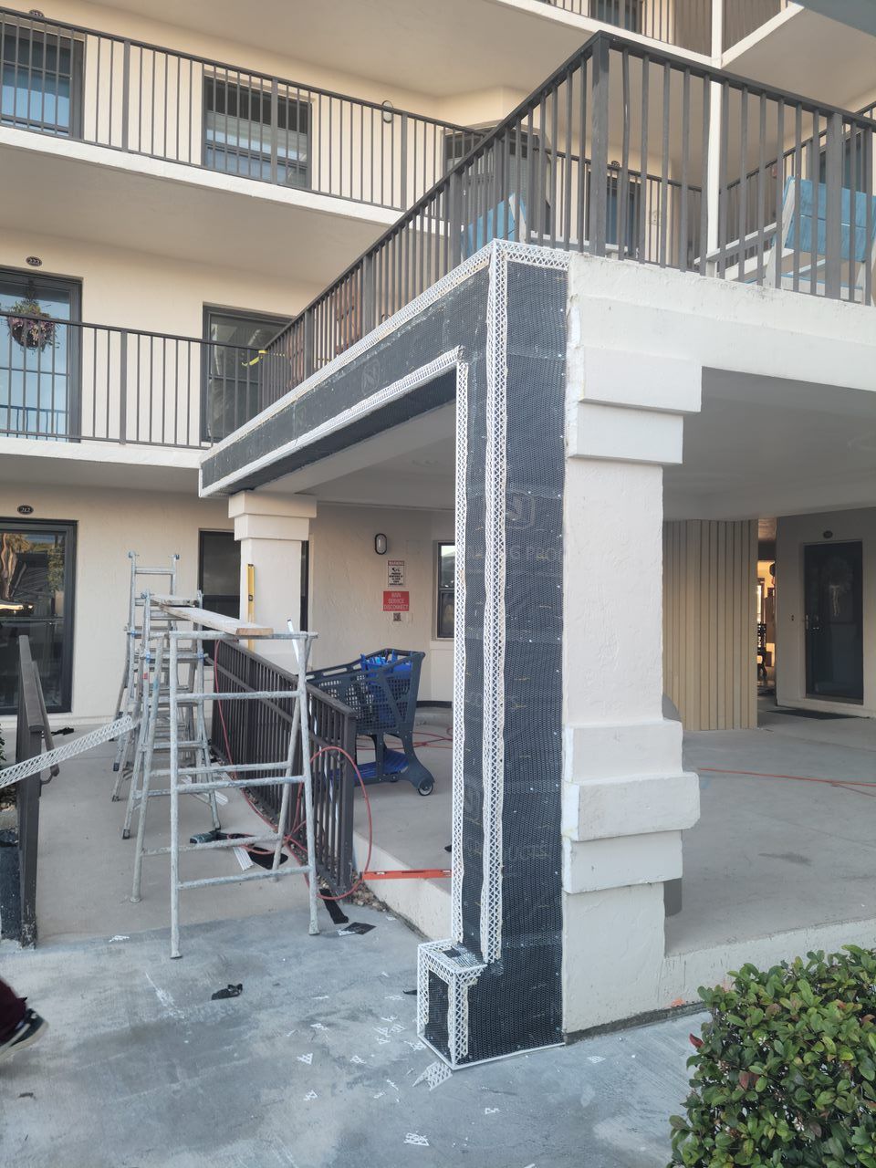 A building with a balcony and scaffolding in front of it