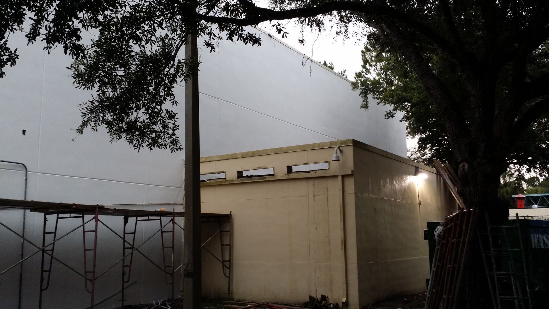 A building with a white wall and a tree in front of it