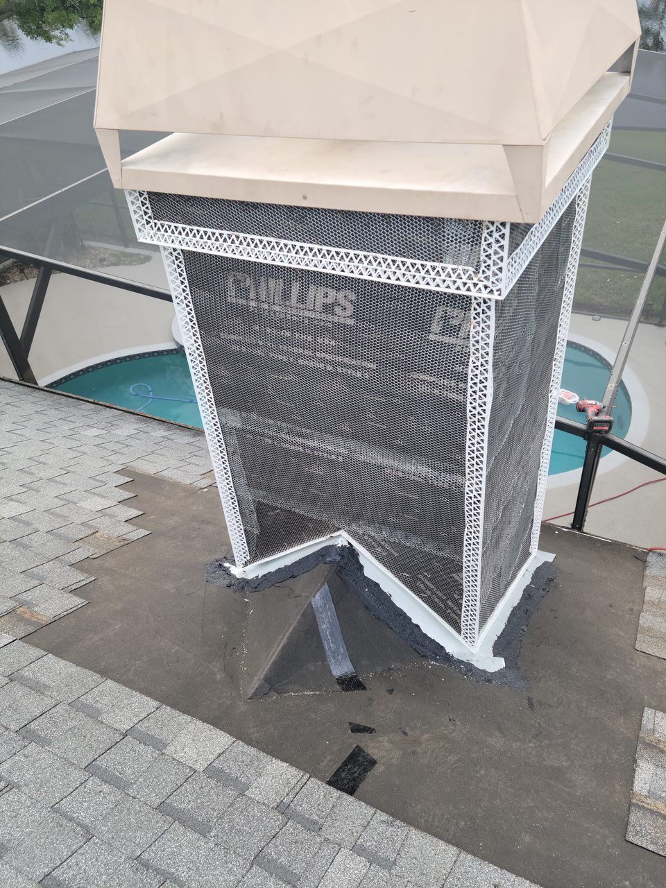 A chimney is sitting on top of a roof next to a pool.