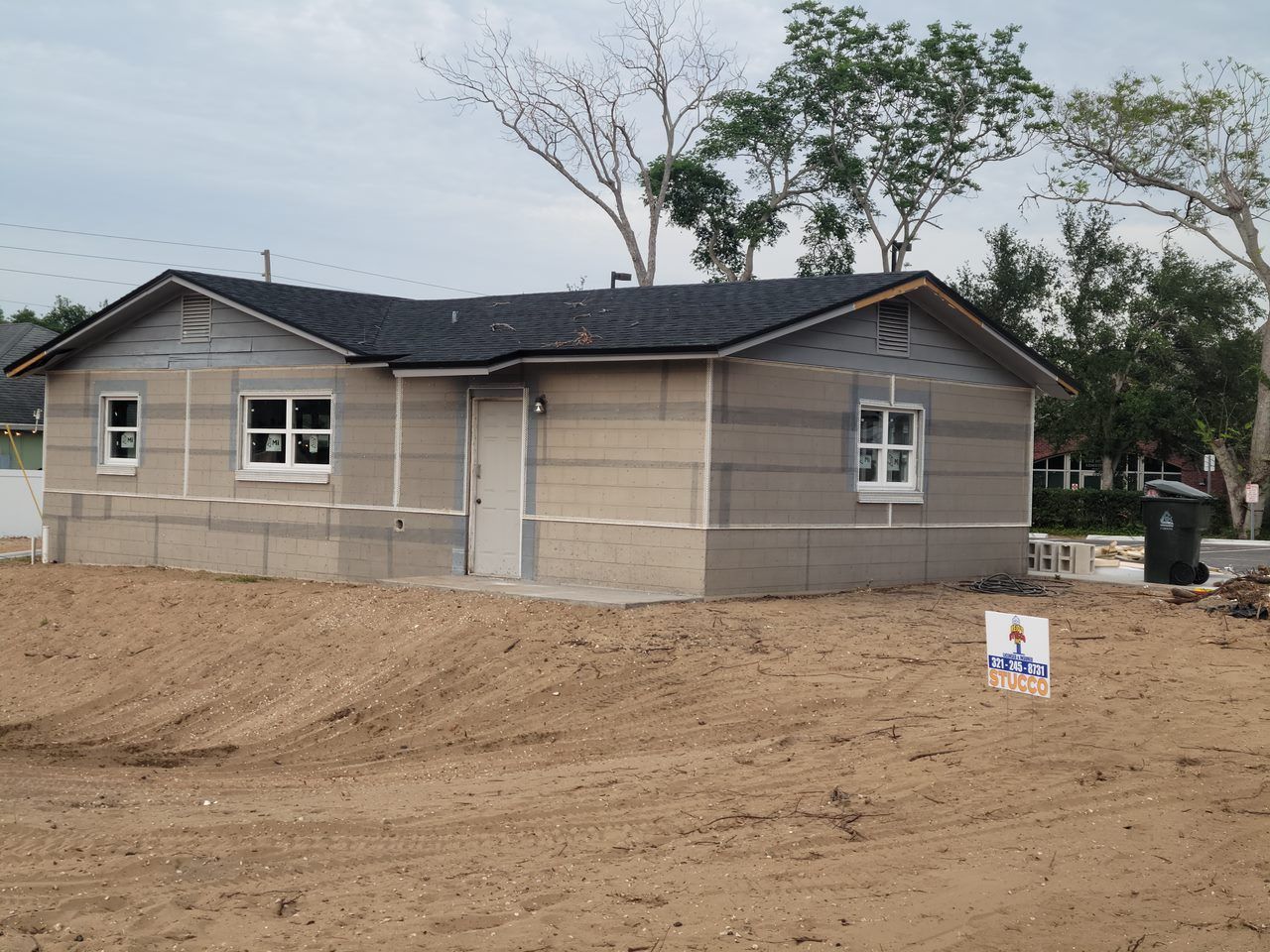 A house that is being built in a dirt field