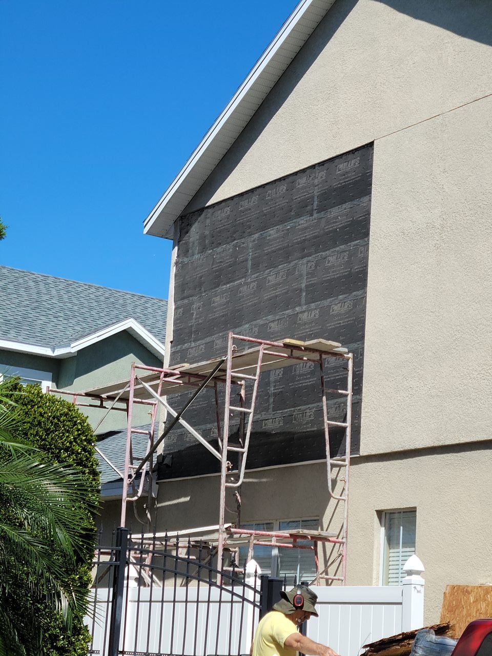 A man is working on the side of a house