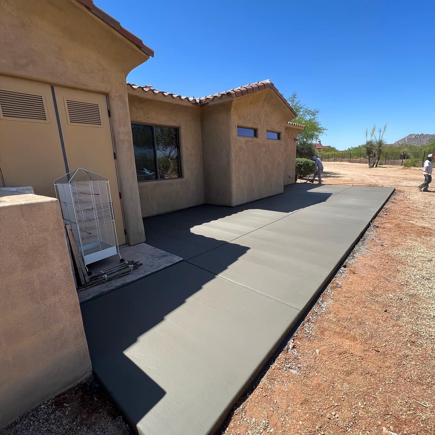 A concrete walkway leading to a house in the desert