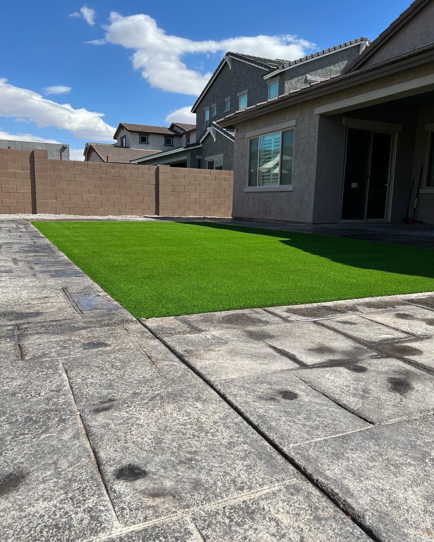 A house with a fence and a lawn in front of it.