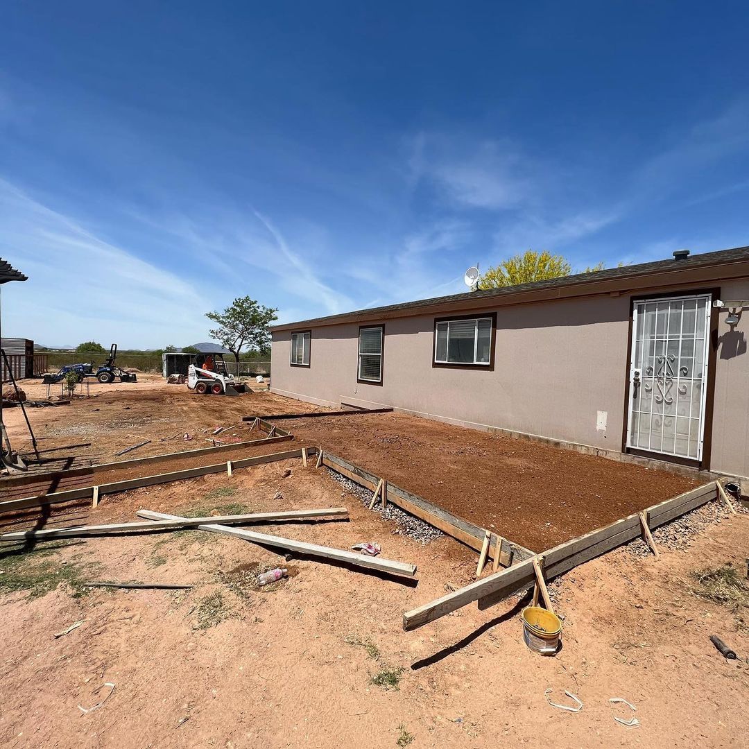 A house is being built in the middle of a dirt field.
