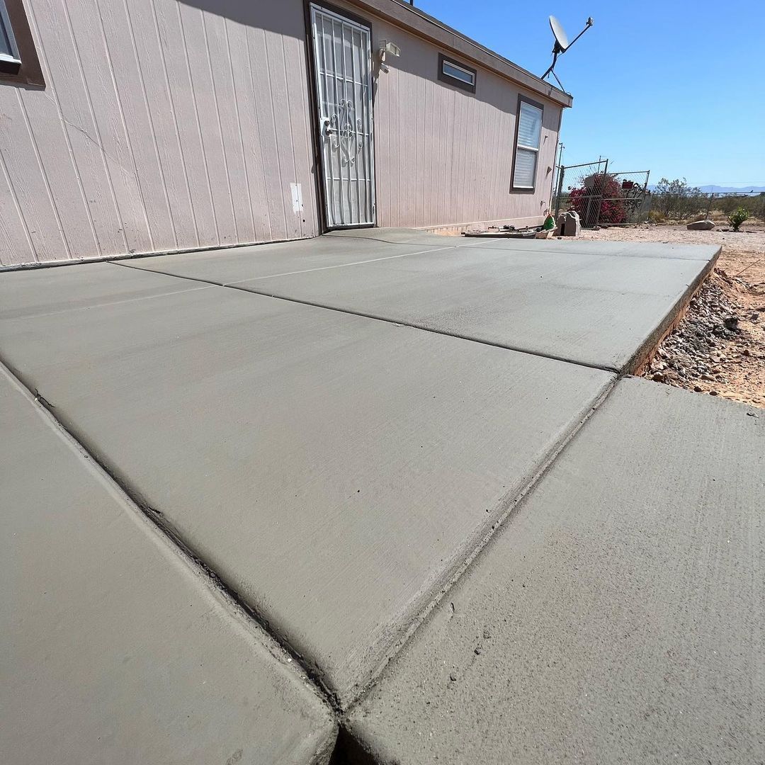 A concrete walkway is being built in front of a house