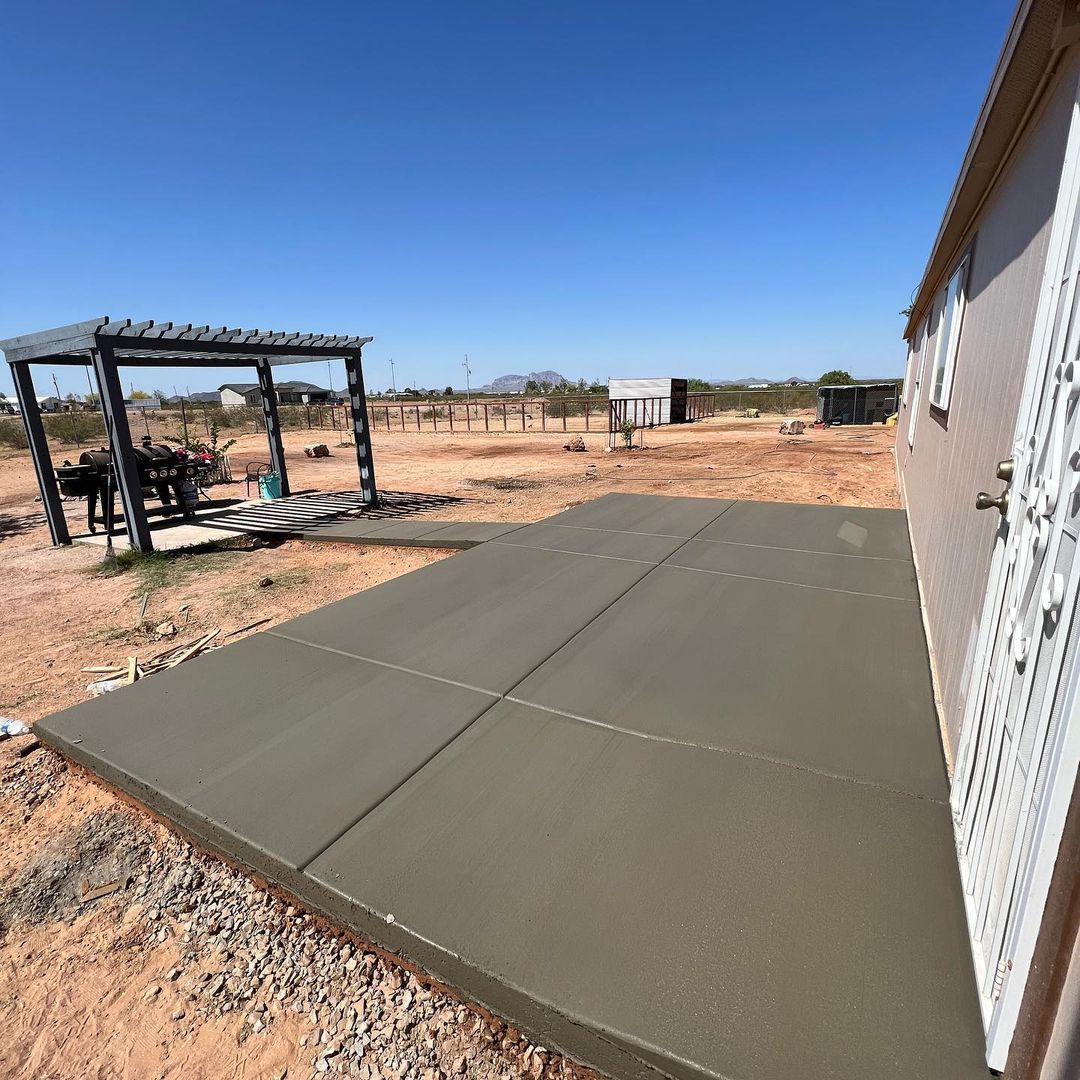 A concrete patio is being built in front of a house.