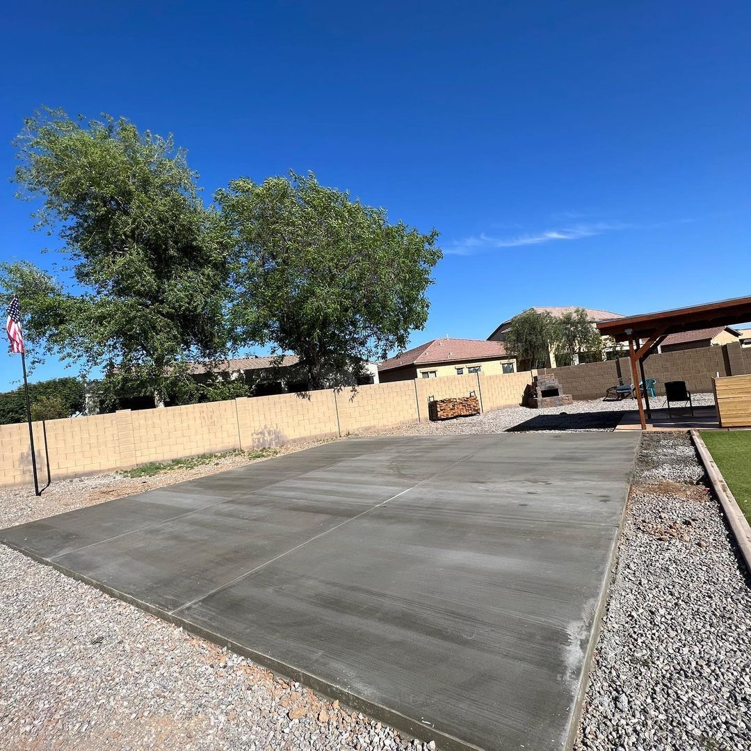 A concrete driveway in front of a house with a flag in the background.