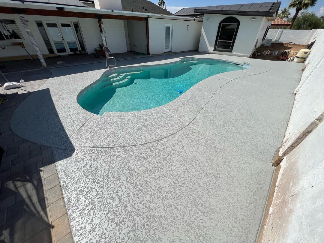 A large swimming pool is in the backyard of a house.