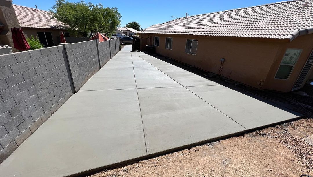 A concrete driveway is being built in front of a house.
