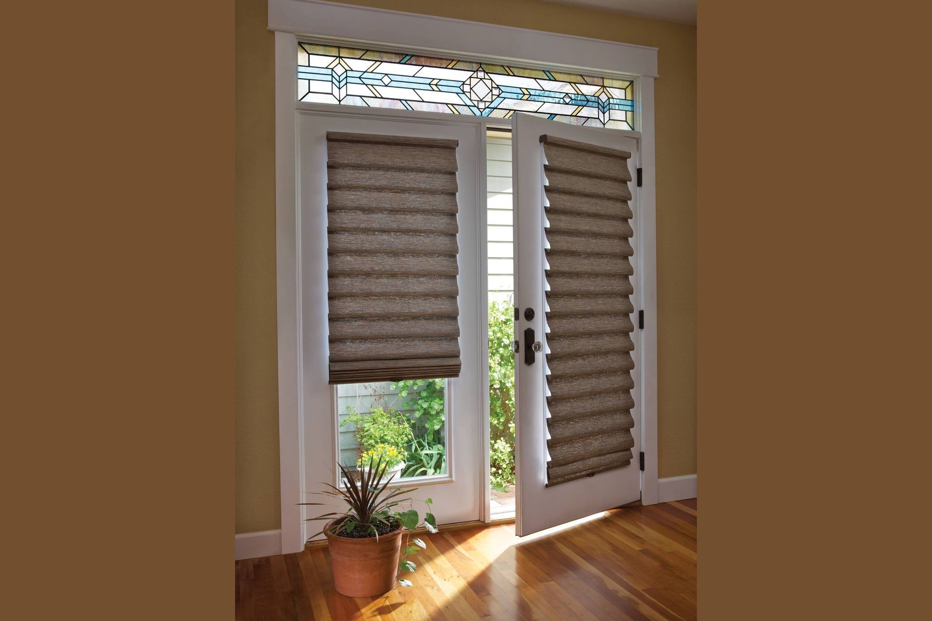 Two white French doors with pleated shades, stained glass transom above, and sunlight streaming in.
