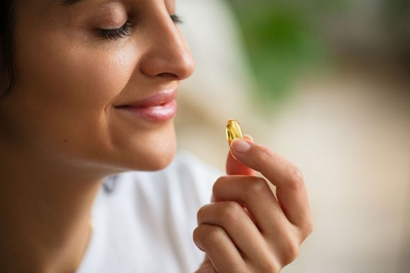 Woman Holding a Yellow Capsule — Highland, UT — Shea's Health & Nutrition