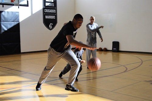 A man is dribbling a basketball on a basketball court