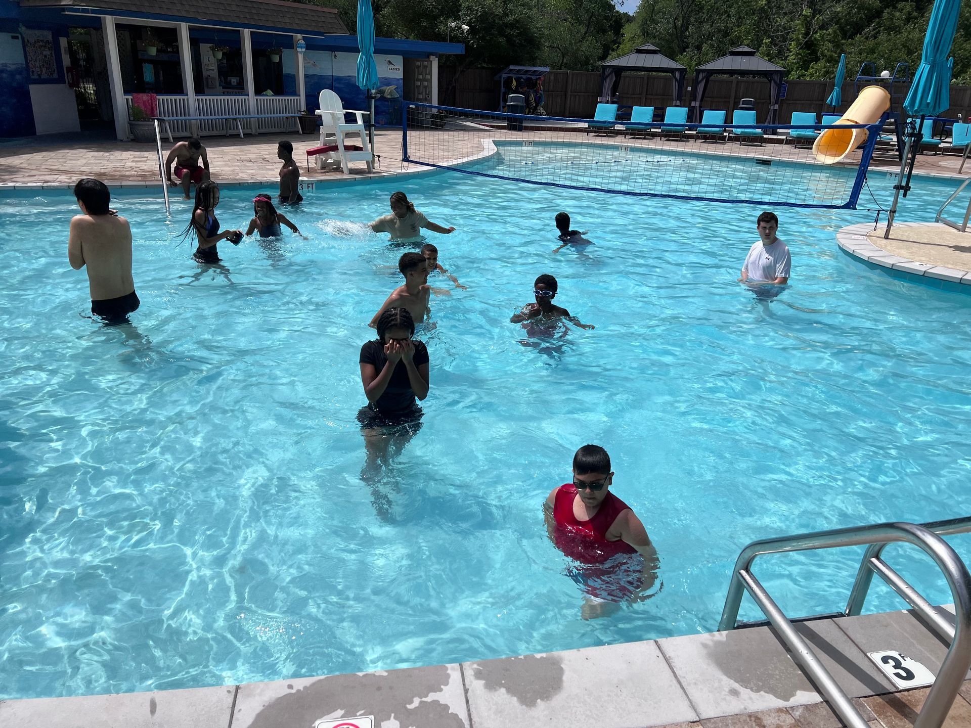 A group of people are swimming in a large swimming pool.