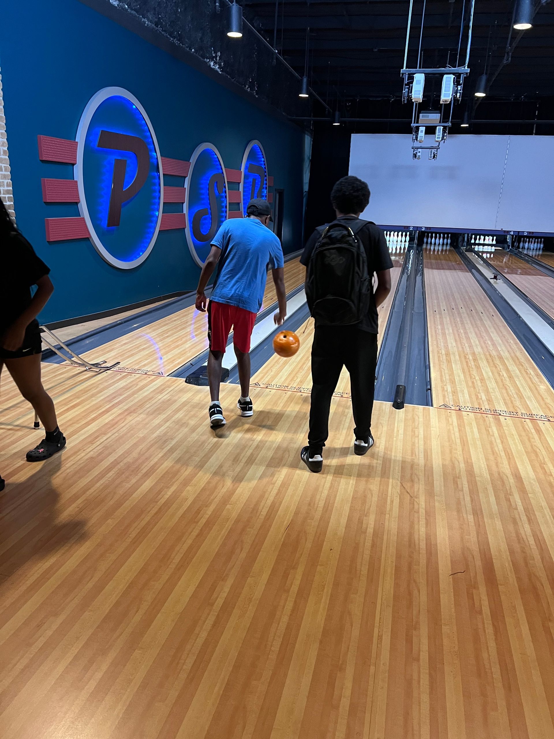 A group of people are playing bowling in a bowling alley.