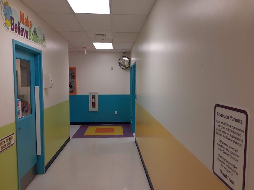 A hallway with a sign on the wall that says make believe