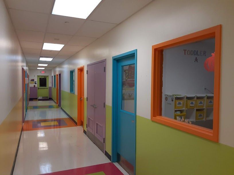 A hallway with colorful doors and a window that says toddler a