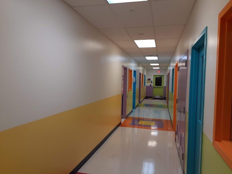 A long hallway with colorful doors and walls