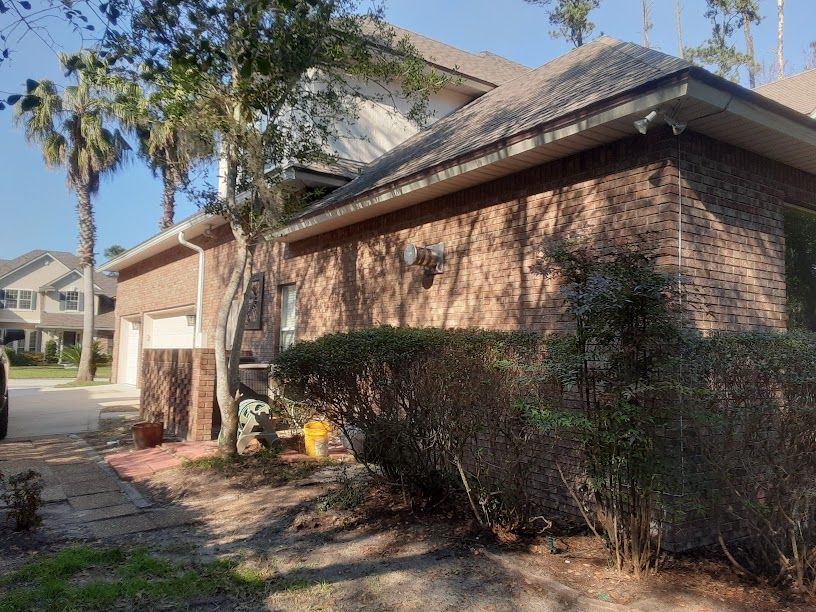 A brick house with a car parked in front of it