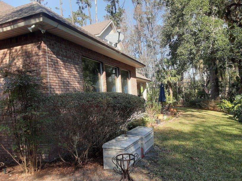 A brick house with a large lawn in front of it.