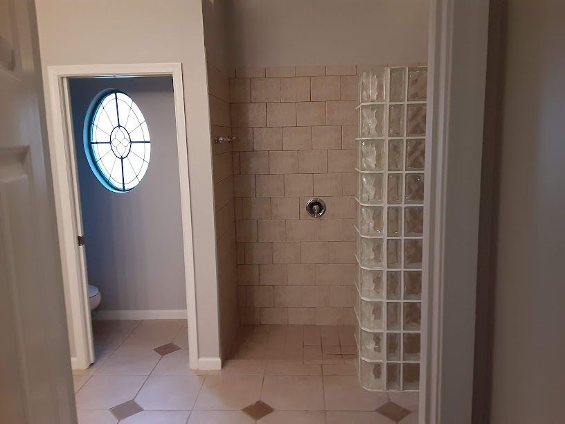A bathroom with a walk in shower and a toilet.