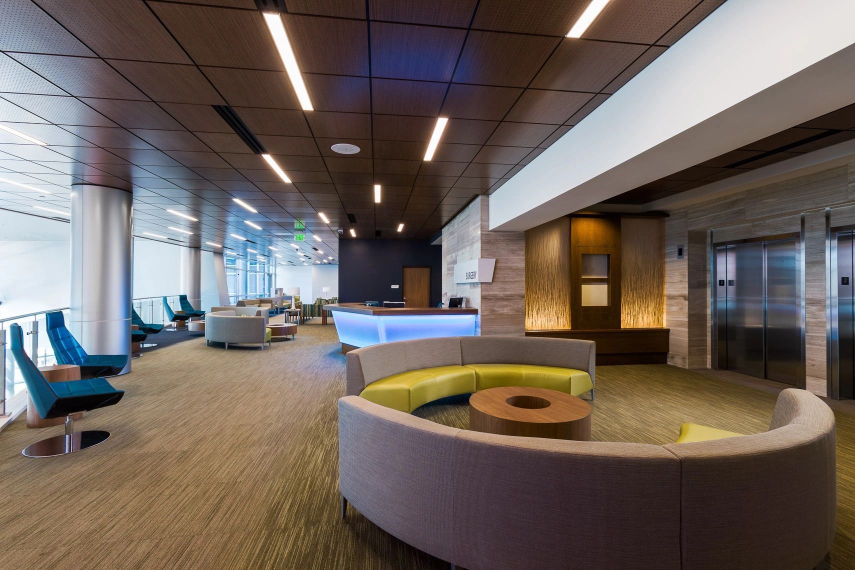 A large lobby with a couch , table , chairs and a counter.