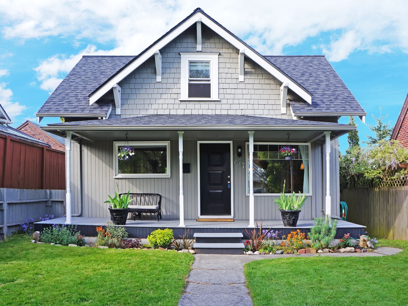 A house with a porch and a bench in front of it.