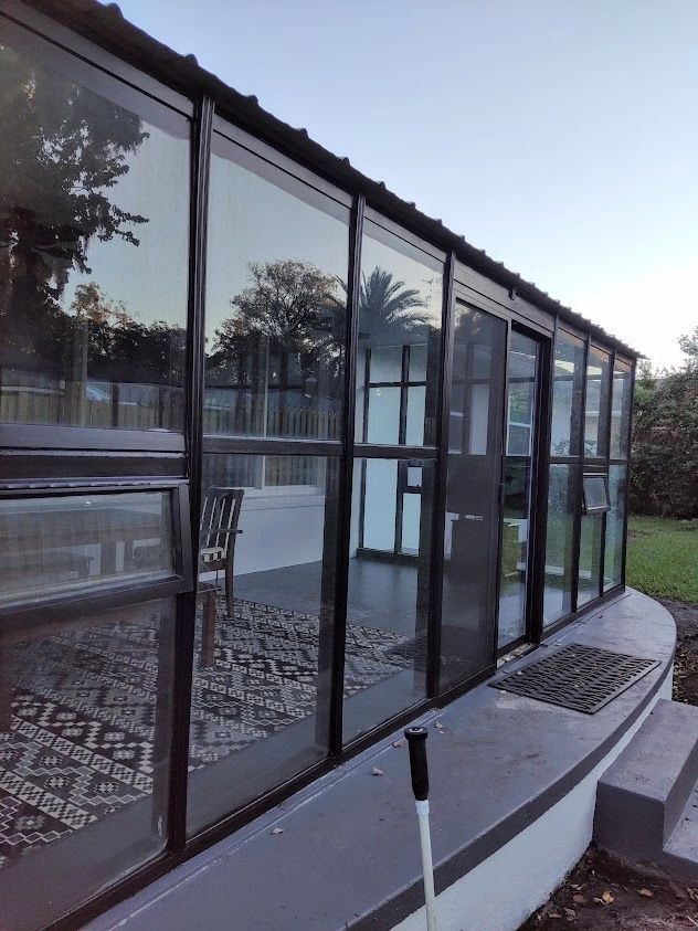 A house with a lot of windows and a shovel in front of it.