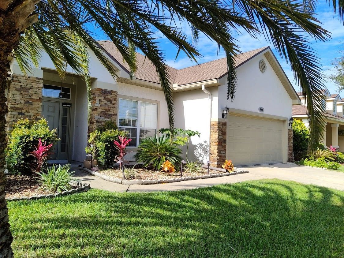 A white house with a palm tree in front of it.