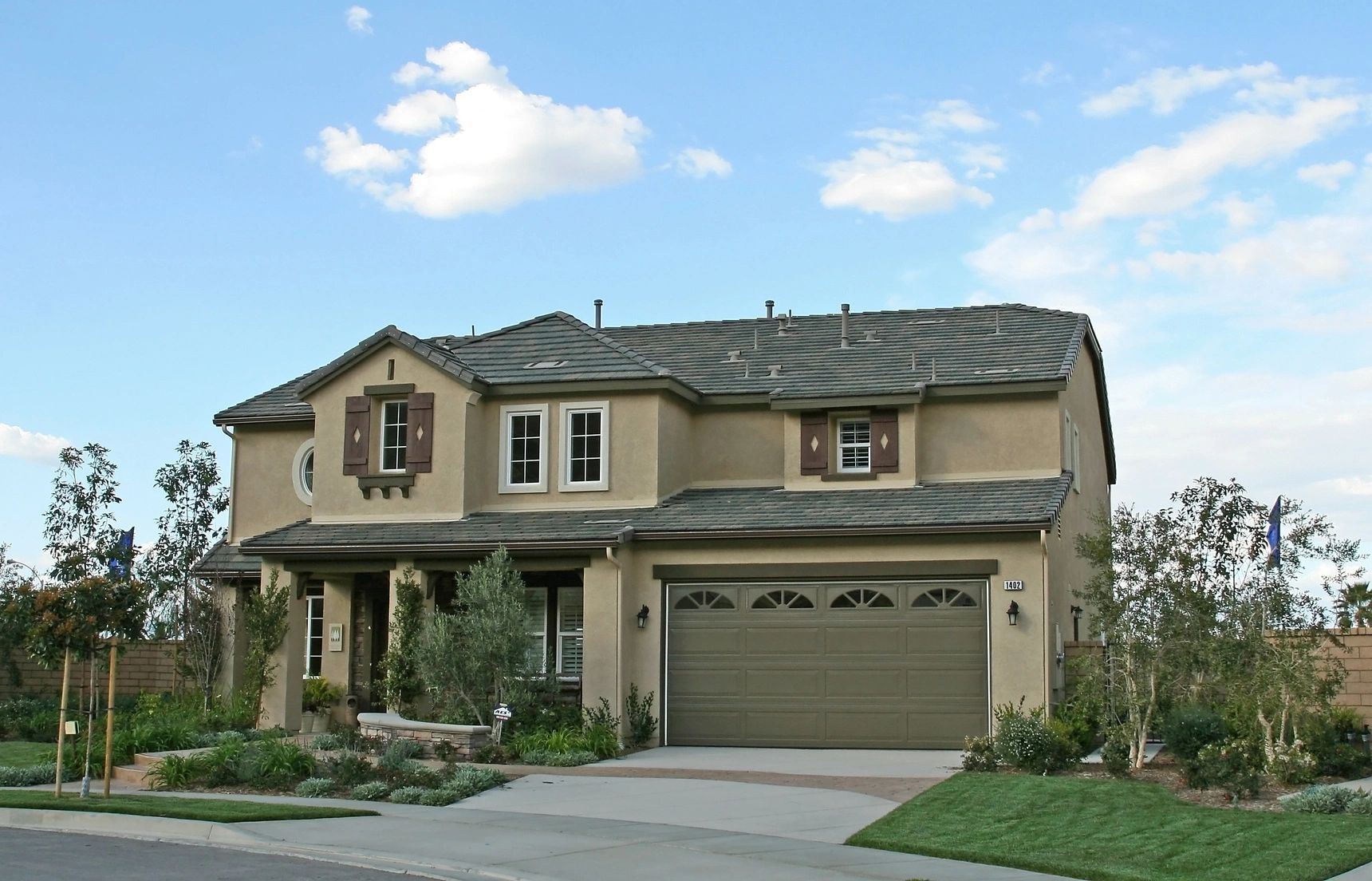 A large house with a garage and a blue sky in the background