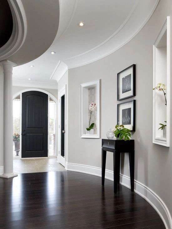 A hallway with a curved ceiling and a black door